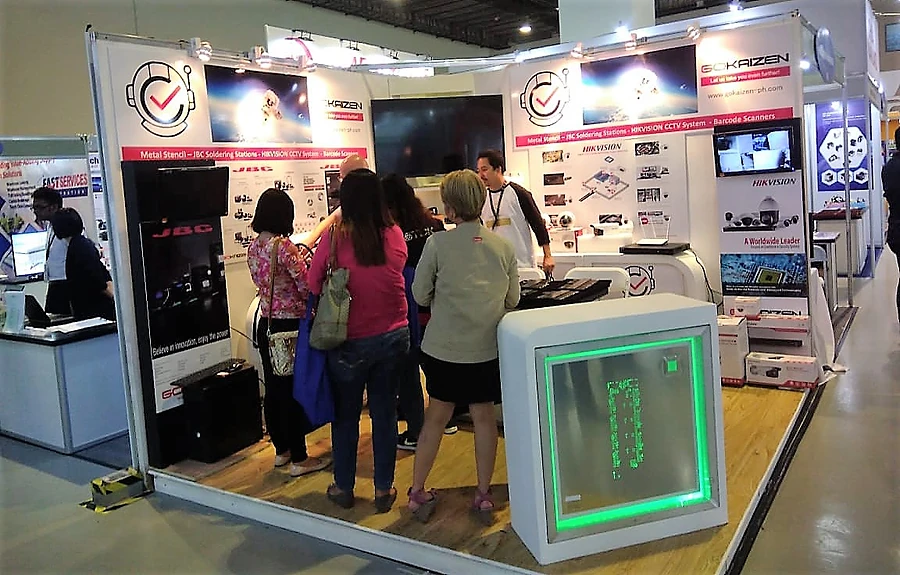The stand busy with visitors, the lit display cabinet in the foreground