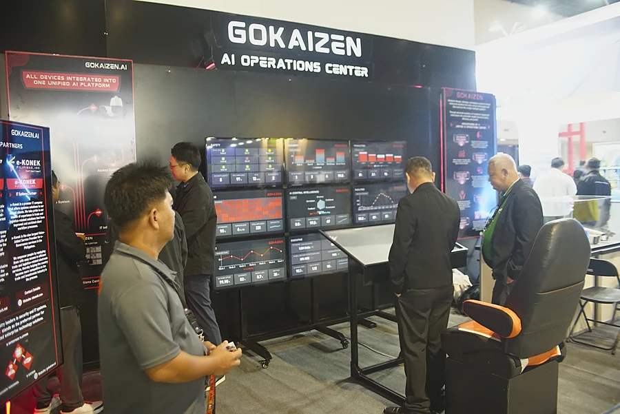 Visitors reading the operations dashboards across the stand's screen wall