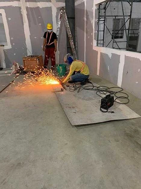 Welder fabricating brackets on site